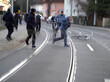 Ein verwackelter Screenshot eines Videos, auf dem mehrere Männer auf einer Straße zu sehen sind, ein Fahrrad liegt am Boden, es sieht wie eine Verfolgungsszene aus.